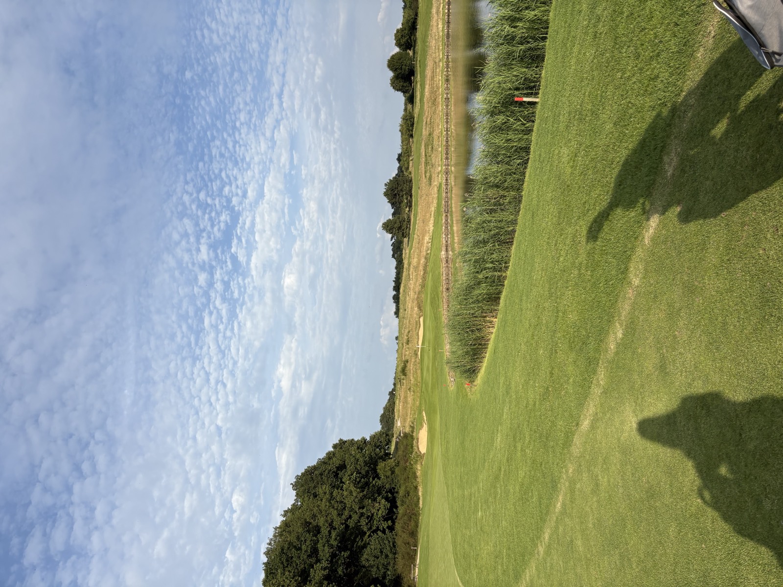 WINSTONopen — Blick über den Fairway mit Teich und Schilfgürtel am Nachmittag